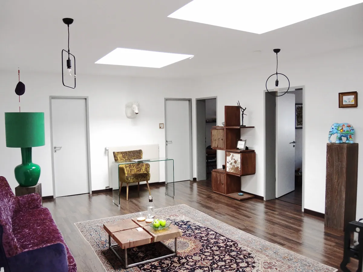 Großer Praxisraum mit Oberlicht, grüner Lampe und Perserteppich